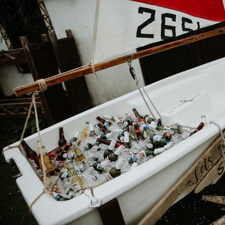 Mini white boat with full of glass bottles of beer for wedding guests to help themselves to 