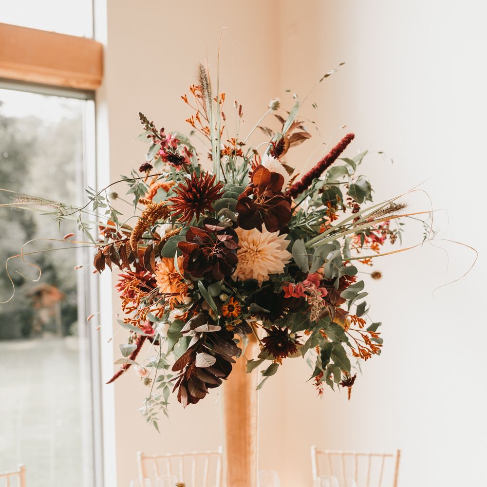 Tall autumn wedding flower centrepiece at Millbridge Court venue in Surrey