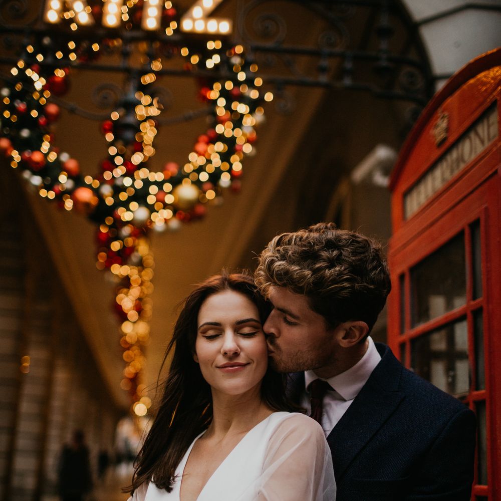 Groom kissing a bride in sheer sleeve wedding dress
