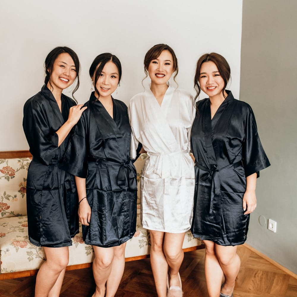 Bride and bridesmaids on the wedding morning in white and black getting ready robes 