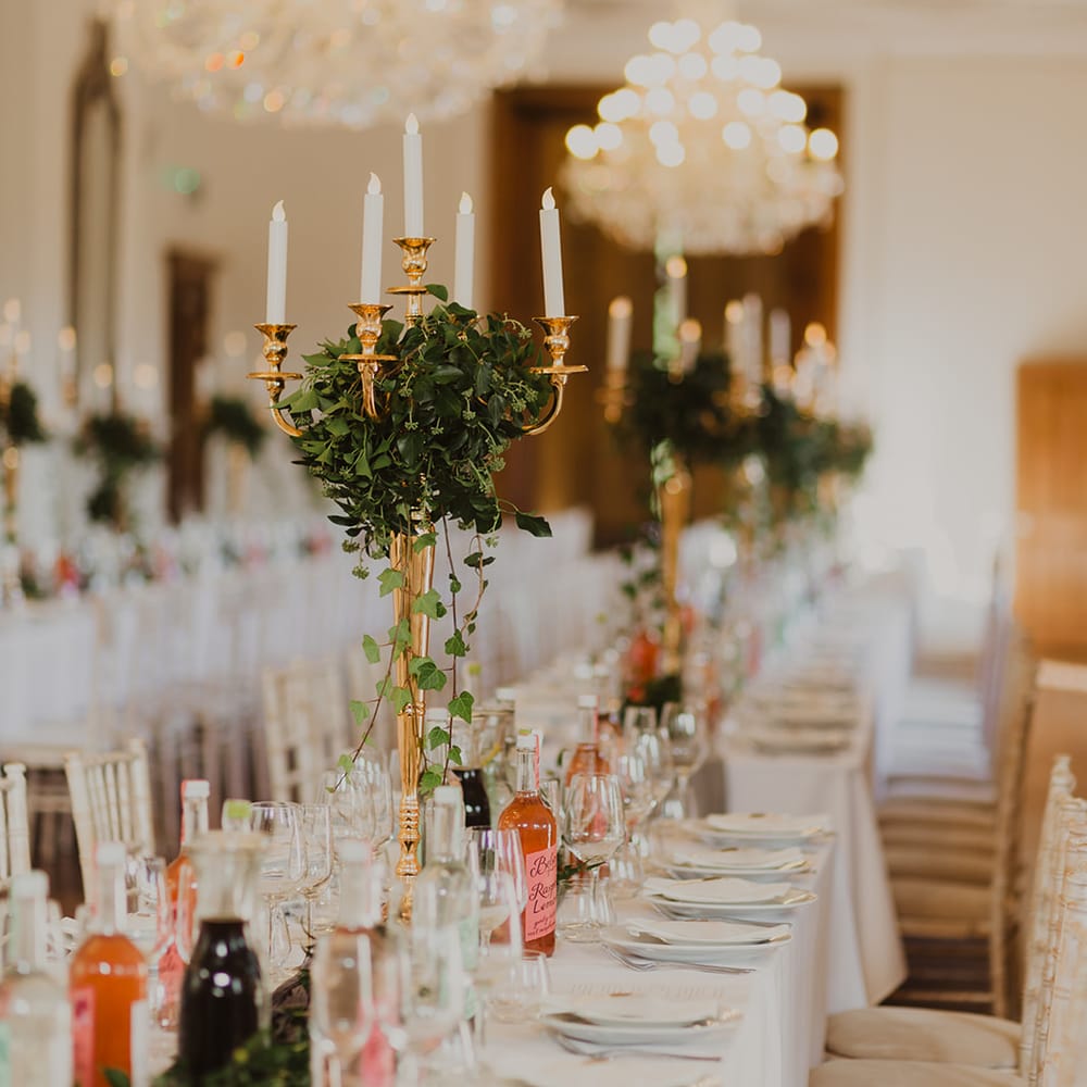 Gold candelabras wrapped in ivy at botanical wedding 