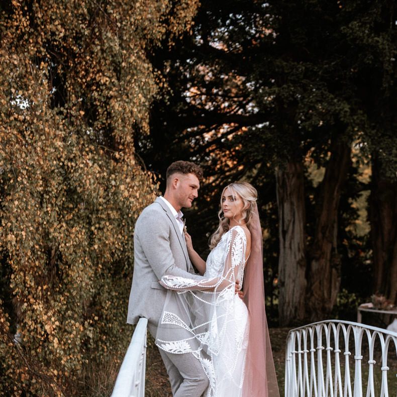 Couple standing over the lake bridge at Preston Court