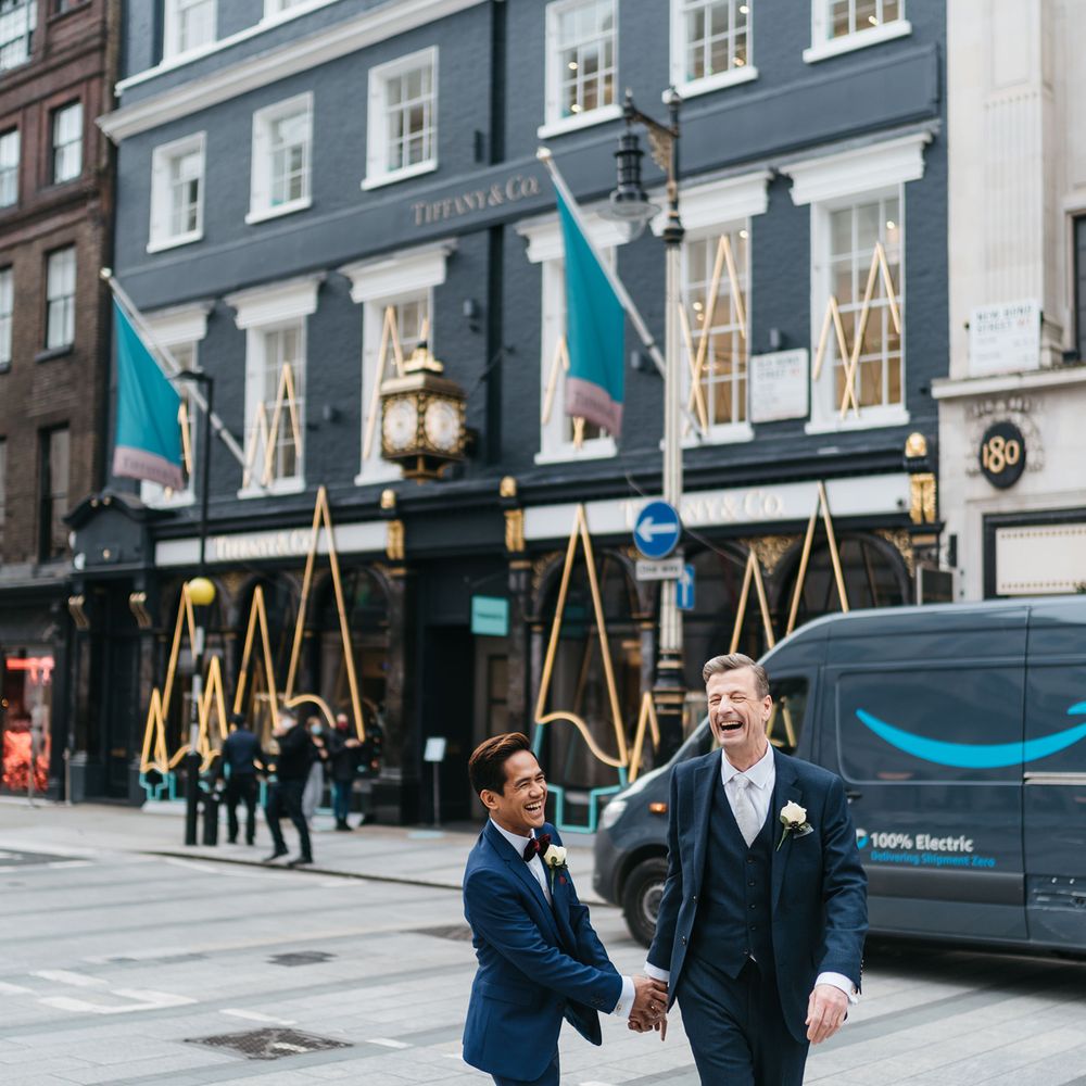 Grooms hold hands and walk through London