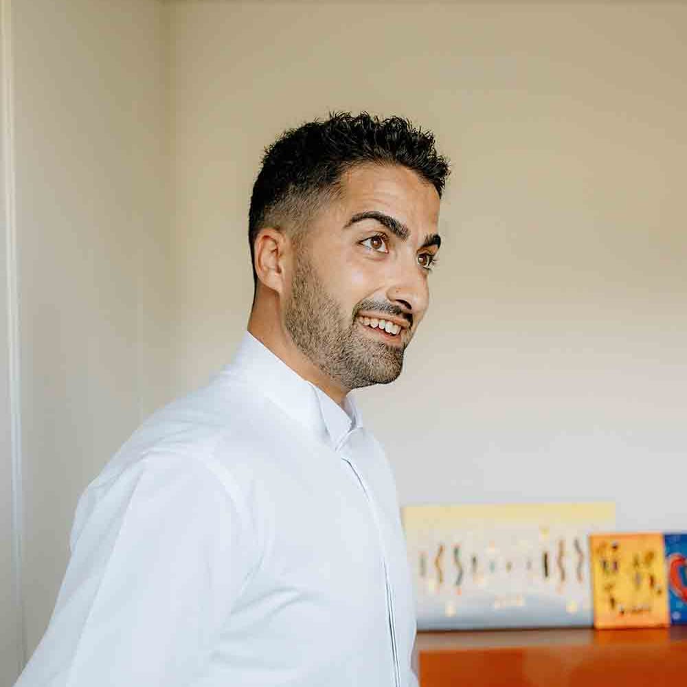 Groom in white shirt preparing for romantic Italian wedding