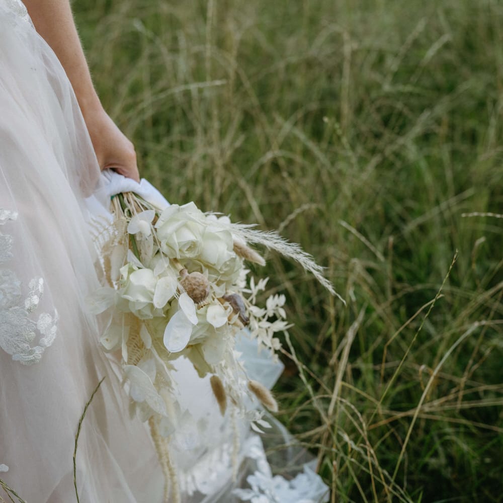 Embroidered tulle wedding dress with all white bouquet for boho style wedding