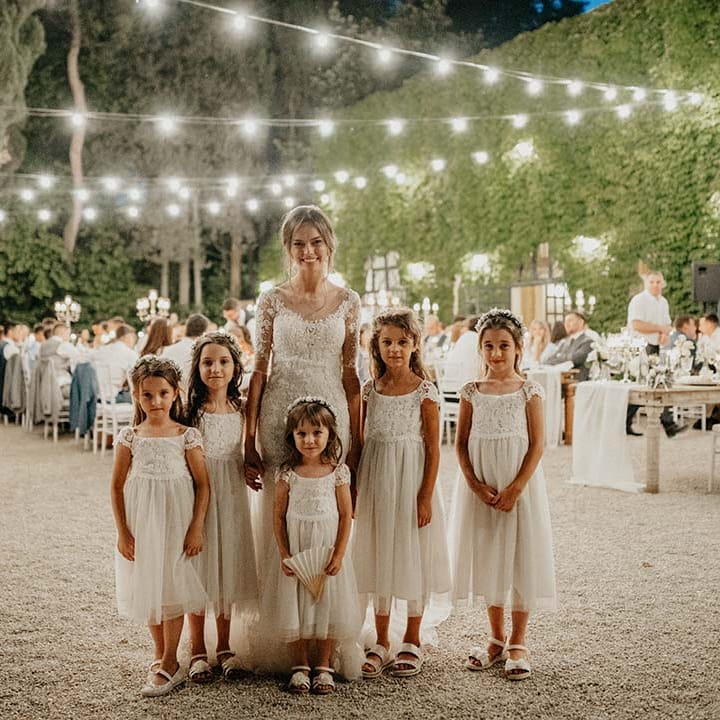 Bride stands with her flower girls outdoors on her wedding day | Royal Studio