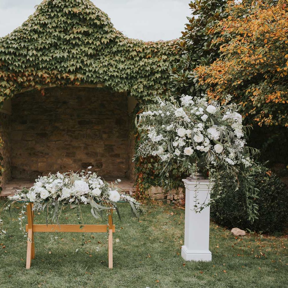 Outdoor aisle at Notley Abbey with green and white floral installations and garlands for outdoor wedding ceremony at Notley Abbey