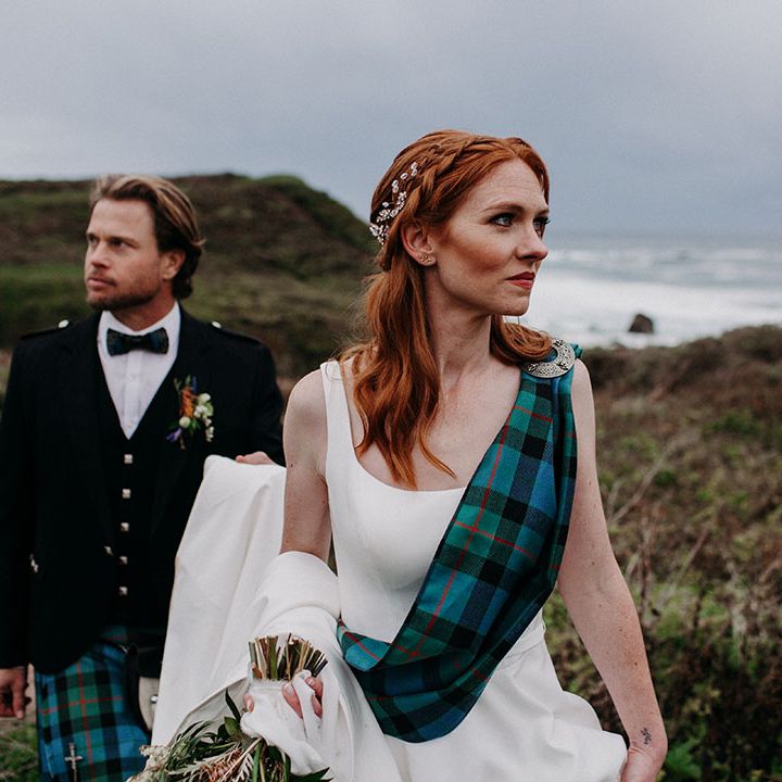 beautiful bride with auburn hair wearing a blue and green tartan sash over her princess wedding dress