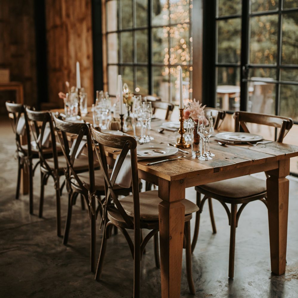 Rustic wooden wedding table with dinner candles, dried florals and glassware for Lake District barn wedding