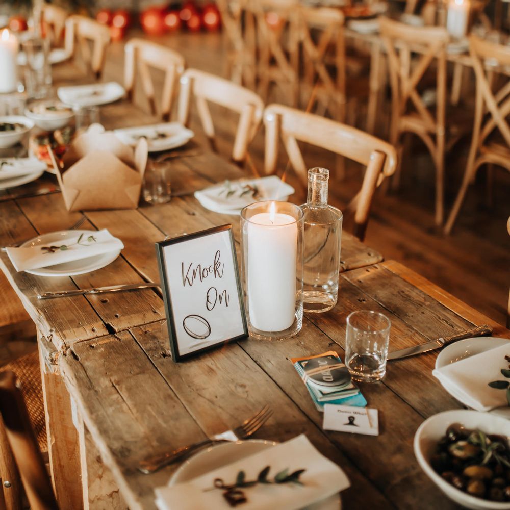 Wooden wedding table with simple rustic wedding tableware and glass candle holders