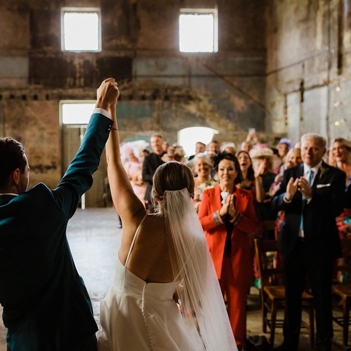 Bride and groom face their wedding guests as husband and wife at industrial wedding