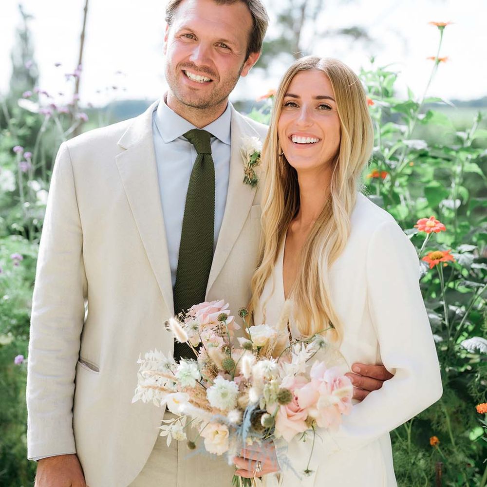 Bride and groom smile at the camera together at their summer garden wedding in Bath