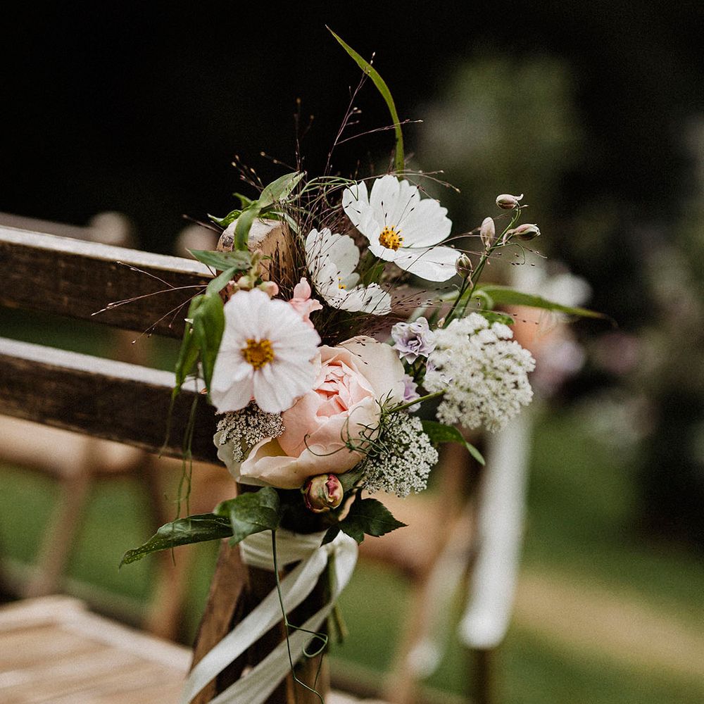 Aisle decoration with white flowers including cosmos and pink roses 