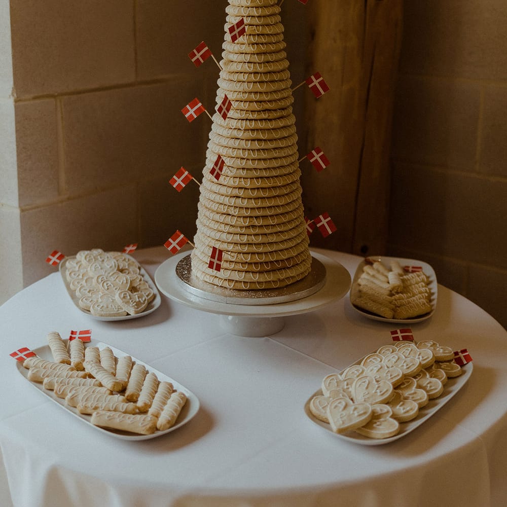 Traditional Kransekake from Denmark with personalised wooden cake topper surrounded by personalised biscuits 