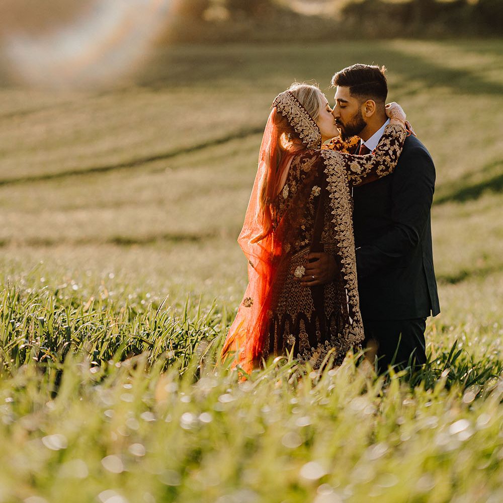 Bride & groom stand within fields during golden hour for couples portraits 