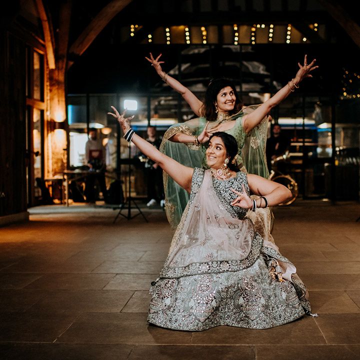 Wedding guests dance during barn reception for multicultural wedding 