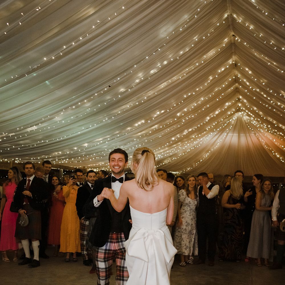 The bride an groom have their first dance in the marquee reception together at The Cowshed Crail 