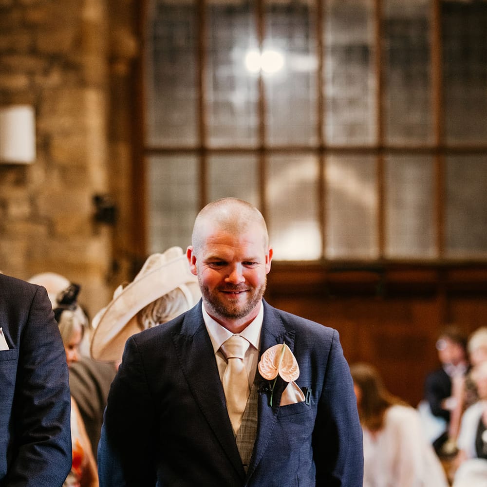 Groom in navy wedding with pink anthurium buttonhole 