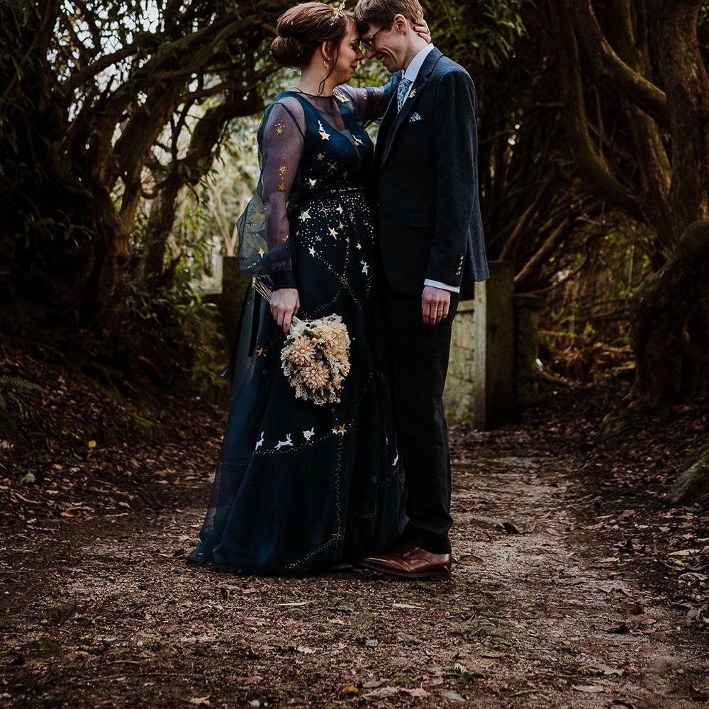 Bride wearing a bespoke dark navy blue wedding dress with gold stars for blue and celestial wedding theme 