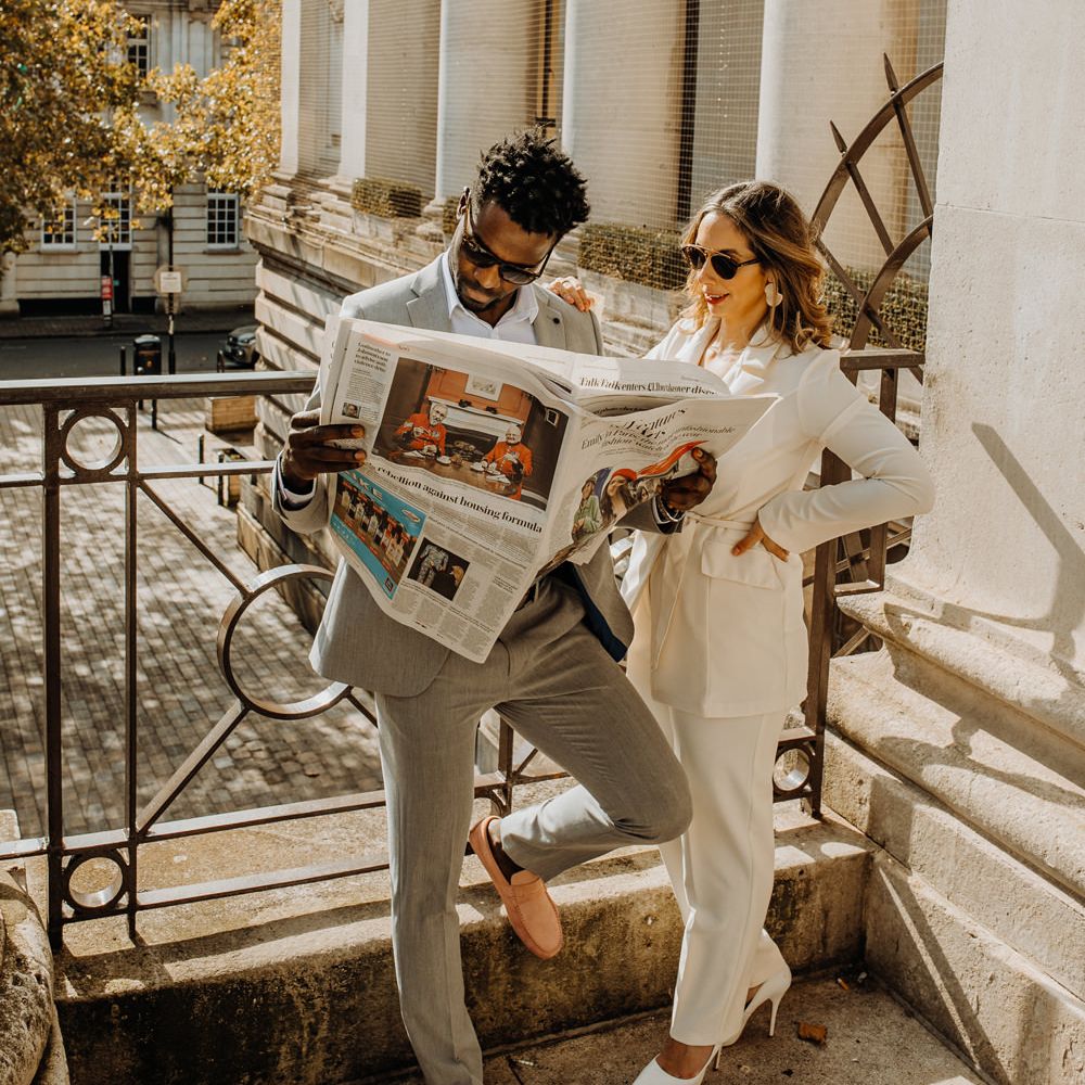 Bride and groom casually reading the newspaper at their intimate elopement 
