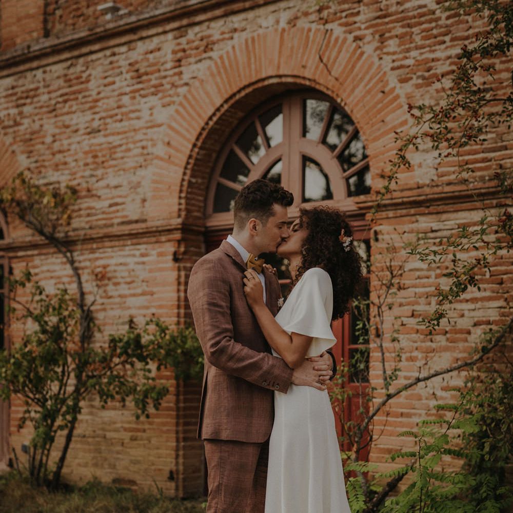 Bride and groom kissing on the grounds of Château de Caumont 