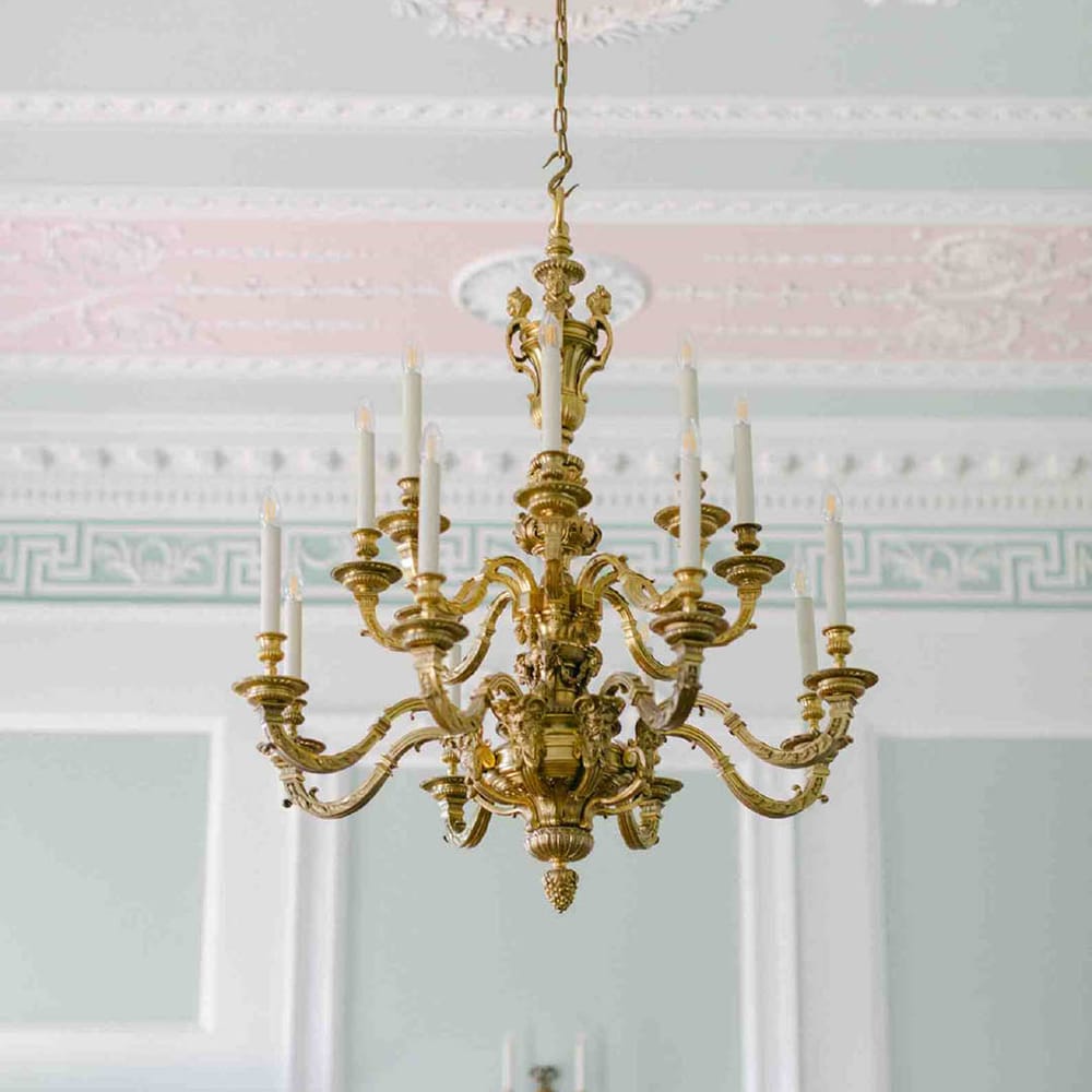 Botley's Mansion reception room with pale green and pink decor and grand chandelier 
