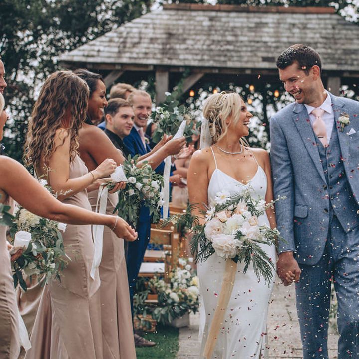 Confetti moment for bride and groom after outdoor ceremony at Trevenna Barns venue in Cornwall
