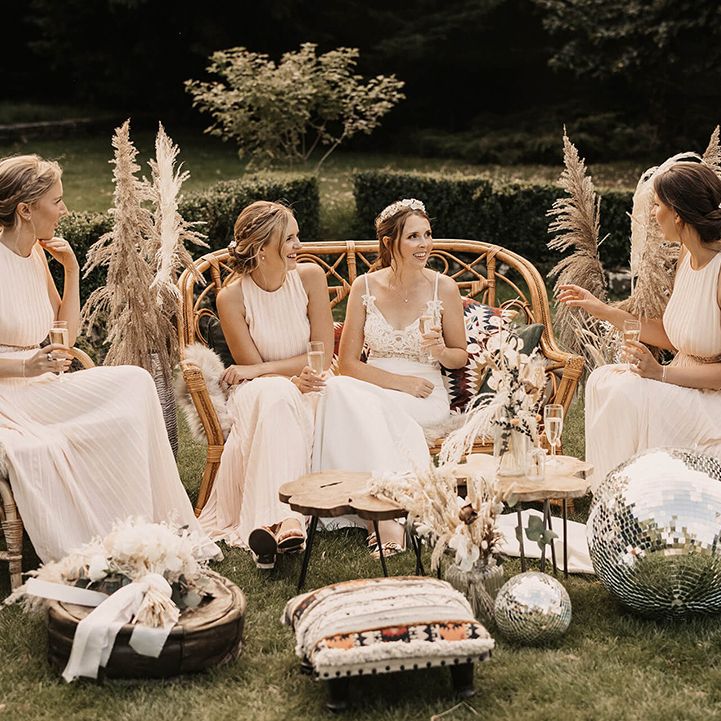 Bride sits outside with her bridesmaids on her wedding day