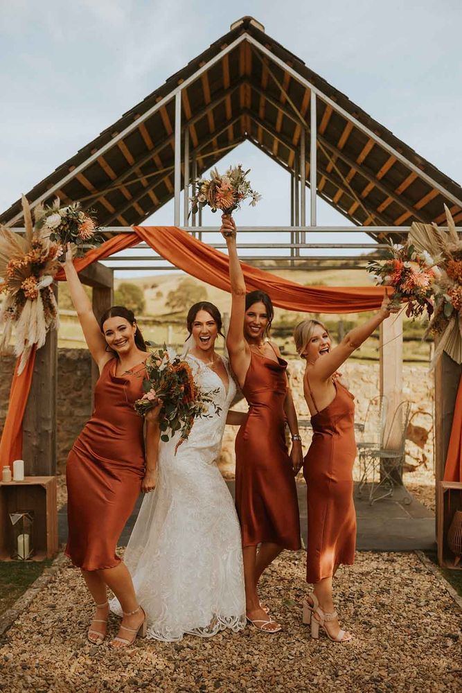 Terracotta Wedding Theme Ideas for a Cozy, Earth-Inspired Celebration 8 https://www.rockmywedding.co.uk/1000x1000/9316/4916/5190/orange-satin-bridesmaid-dresses-laura_dean_photography-571.jpg?fit=1