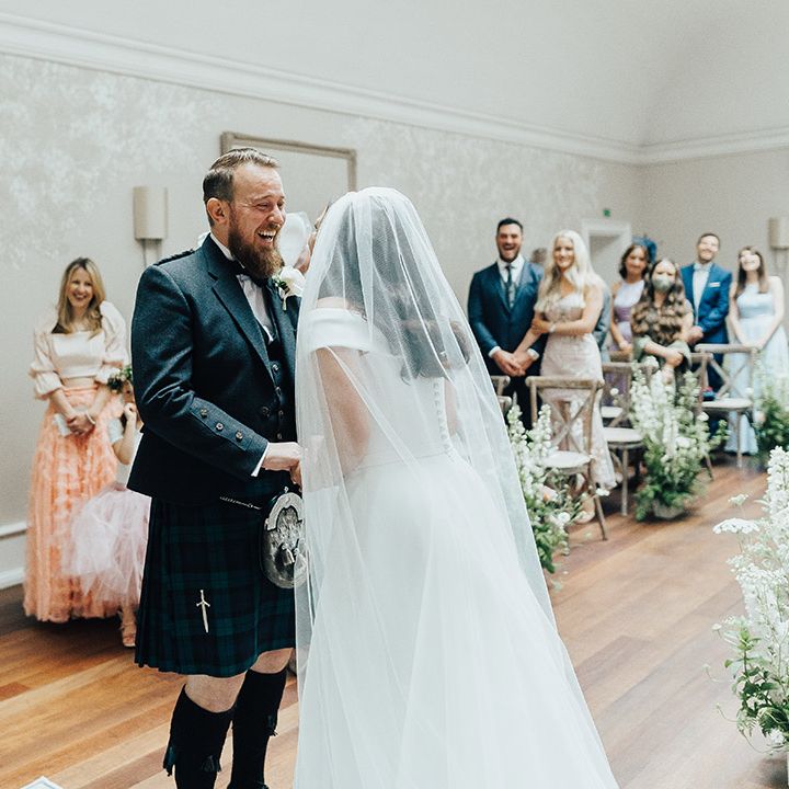 Luxury English micro wedding with groom in a tartan kilt and bride in a Suzanne Neville wedding dress and chapel veil 