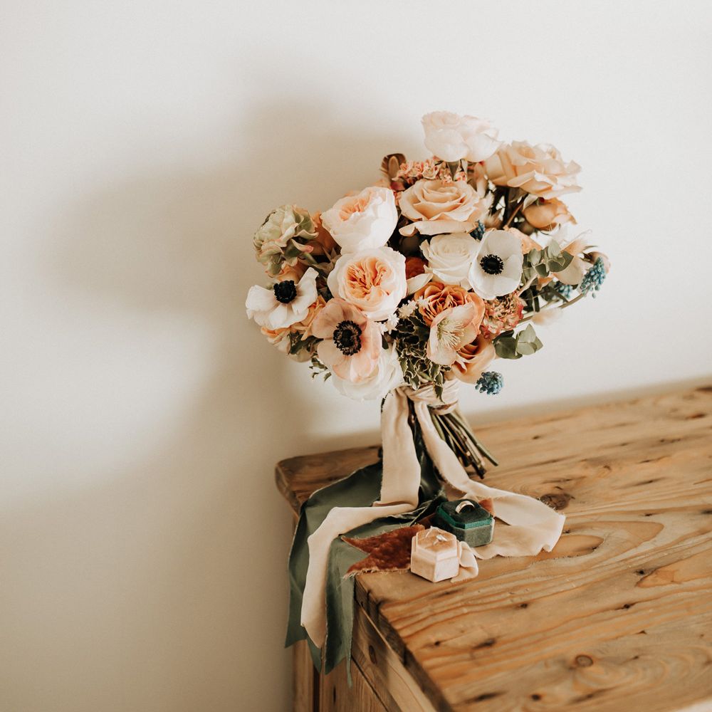 Mixed pastel wedding bouquet with roses tied with pink and green ribbon
