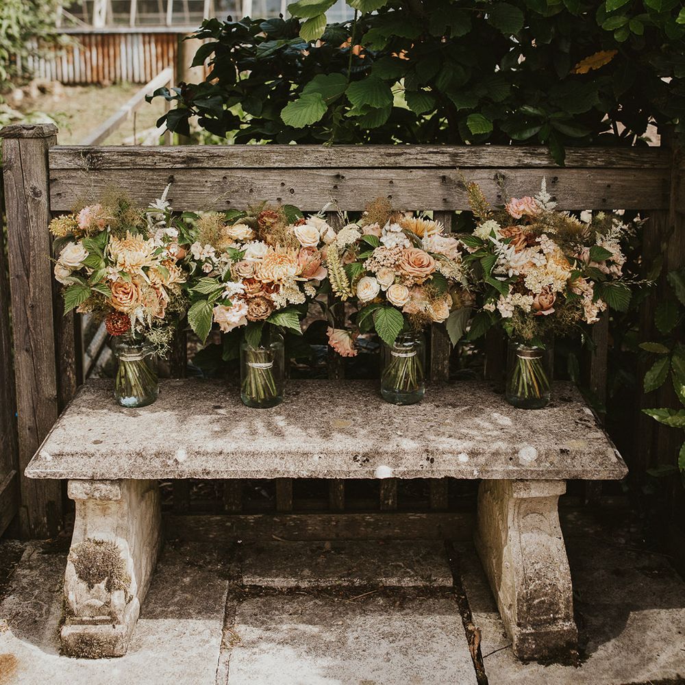 Bridesmaids bouquets sit in vases of water before the wedding 