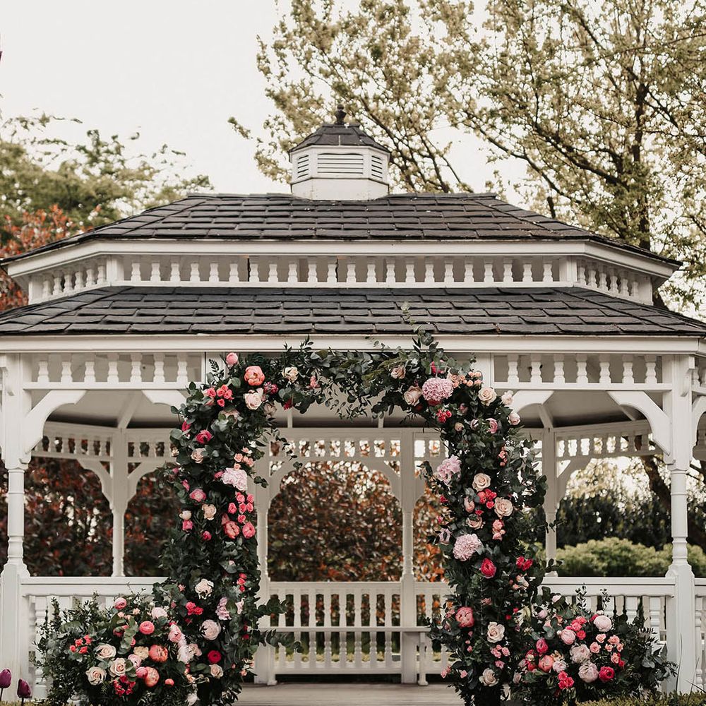 Pink flower arch with pink florals for the outdoor ceremony at The Old Kent Barn