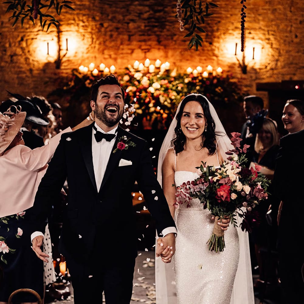 Bride and groom can't stop beaming as they walk back down the aisle to confetti 