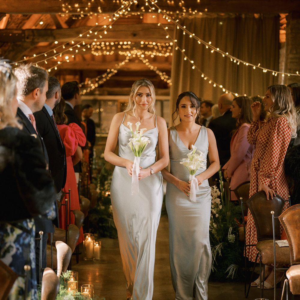 Bridesmaids in light sage green satin bridesmaid dresses with lily bouquet and gold metallic shoes 