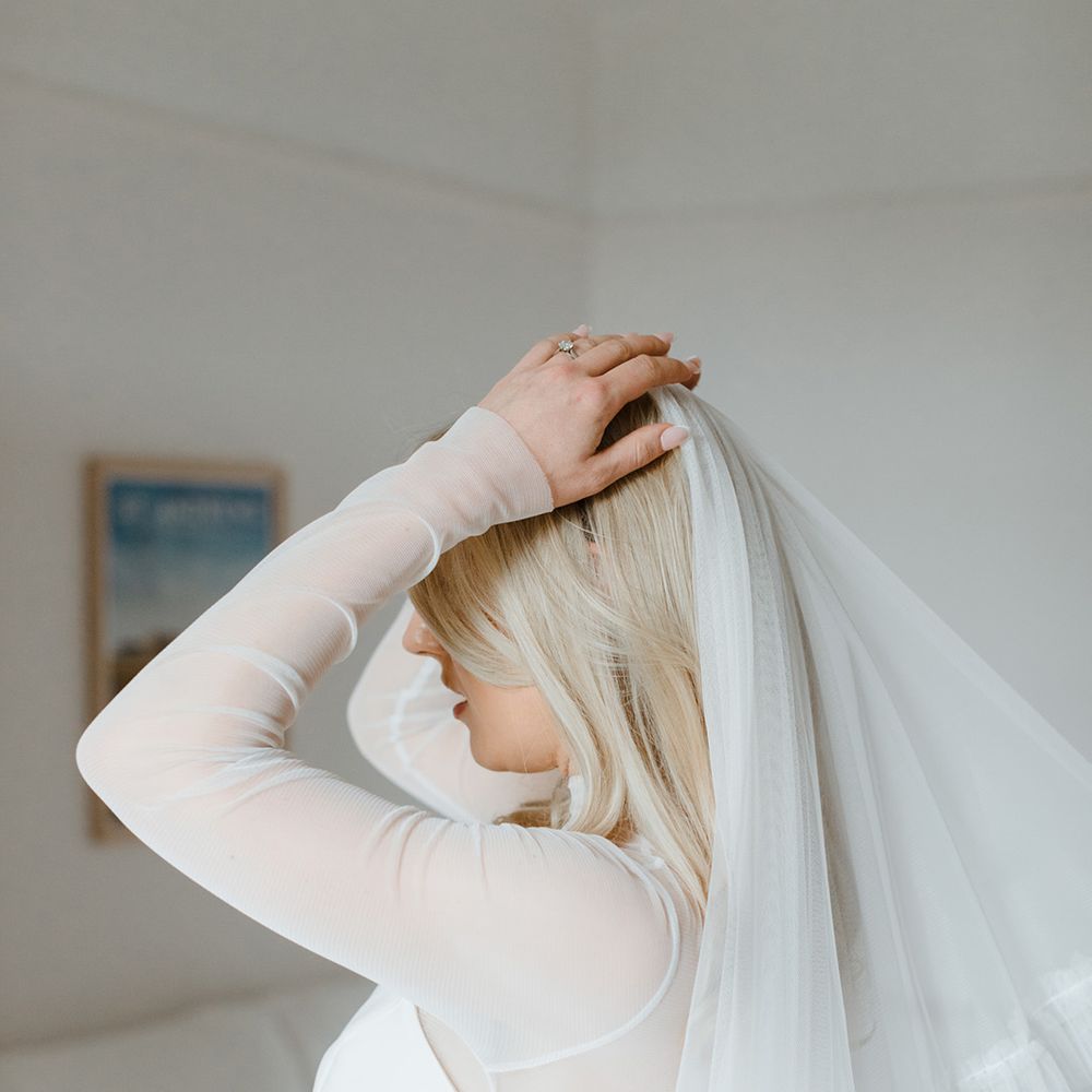 Bride puts on her wedding veil for the day 