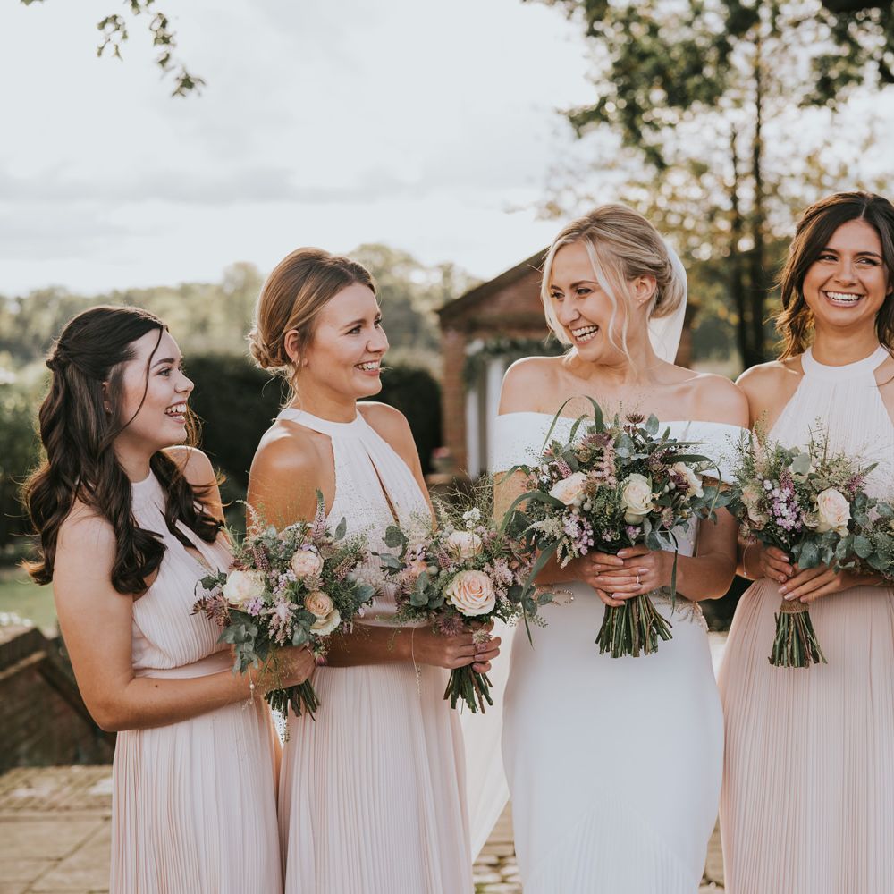 Bride stands with her bridesmaids outdoors