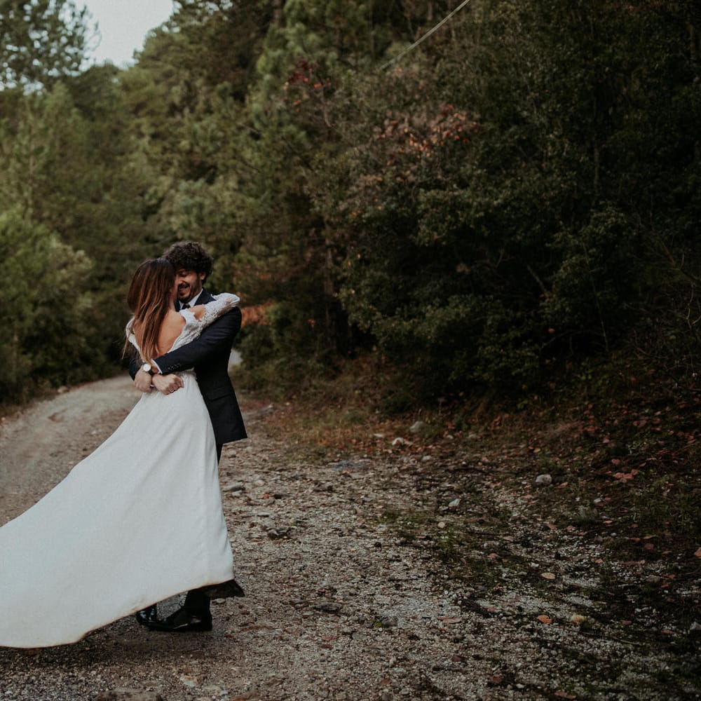 The groom swings the bride around, her dress flowing in the breeze