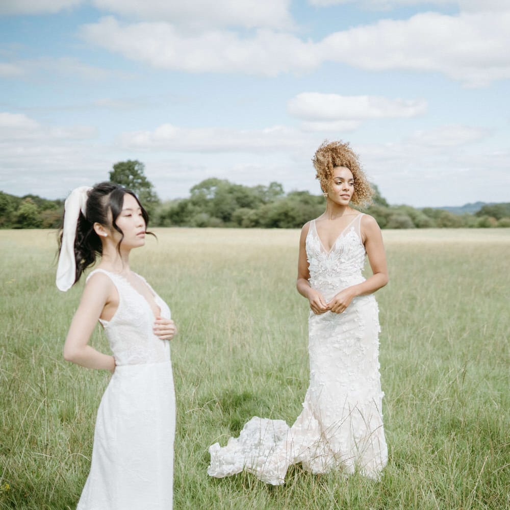 Three brides in the fields at Berwick Lodge wearing boho inspired wedding dresses from Made With Love and Emmy Mae Bridal