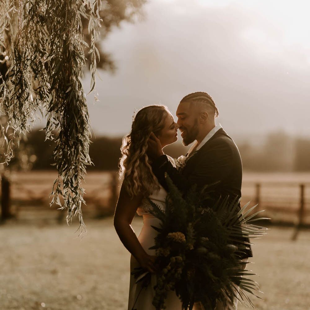Bride and groom at twilight in a country field 