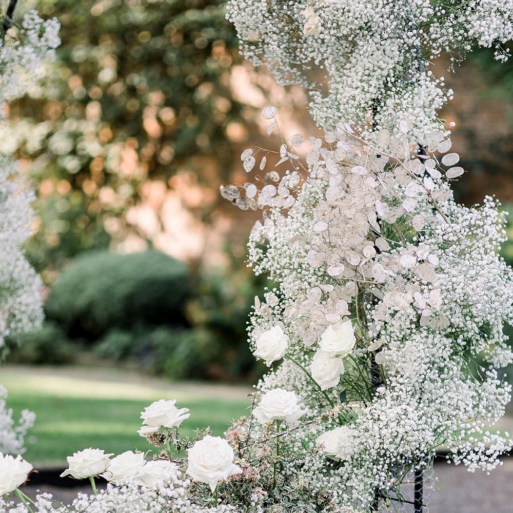 Gypsophila and white rose floral arch and pillar candles in cylinders 