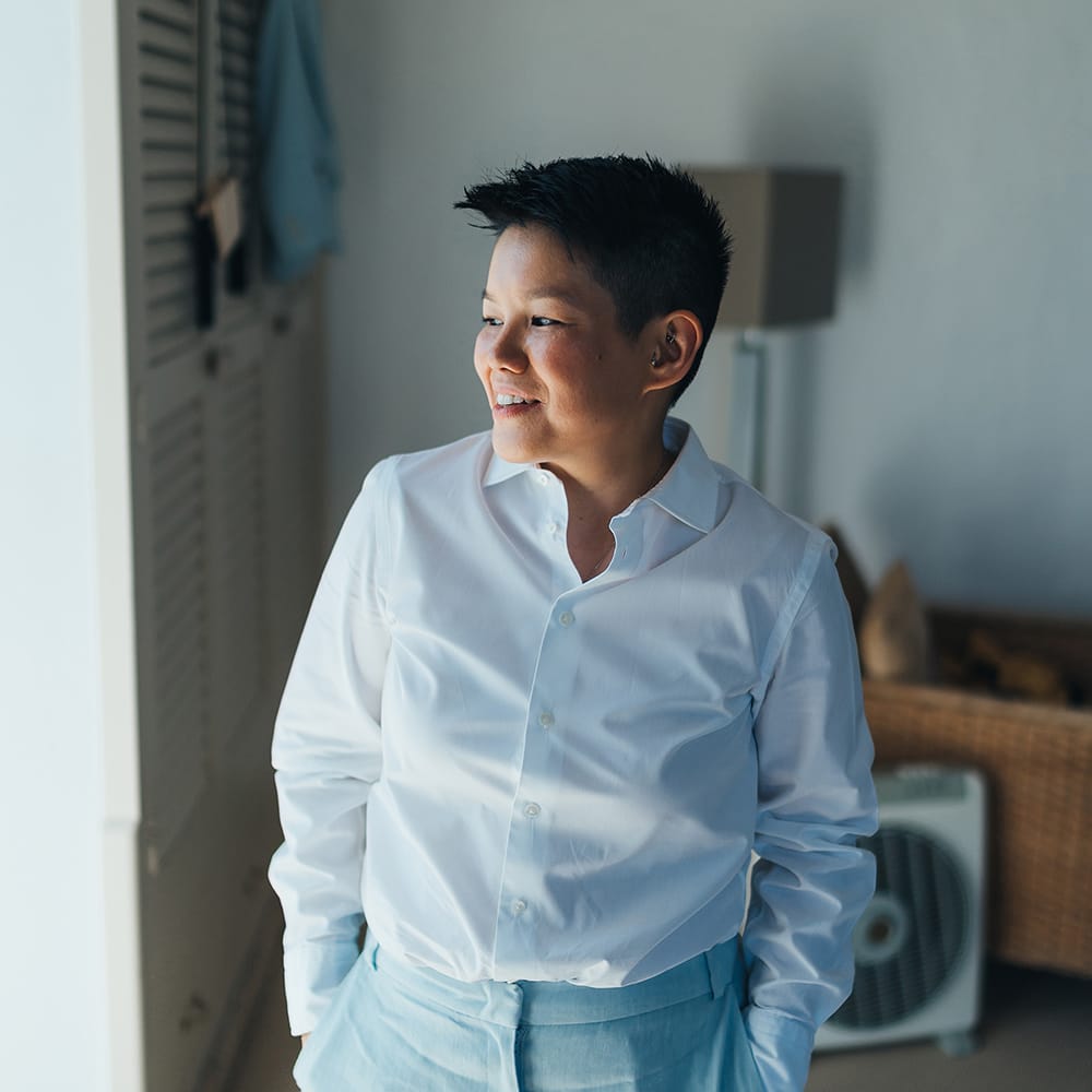Bride wears pale blue suit and white shirt on her wedding day 