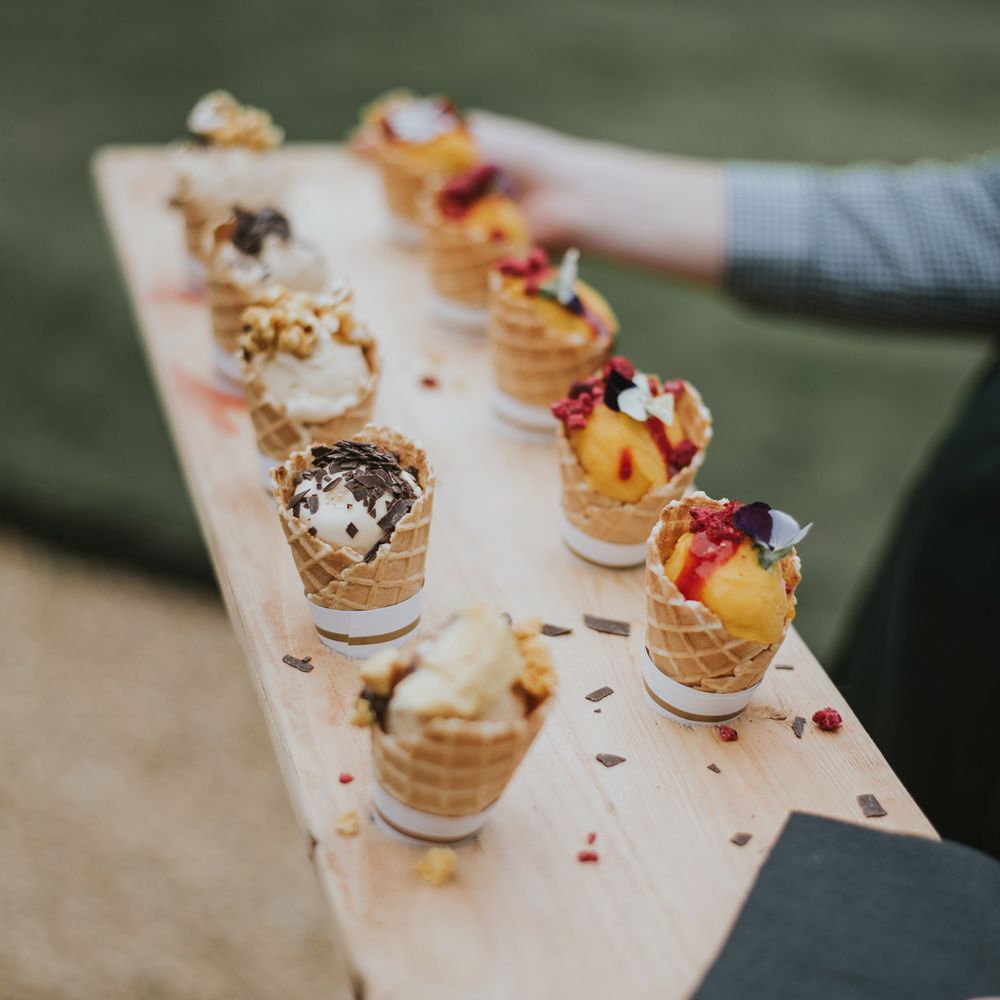 Wooden board with mini ice cream canapés at Tythe Barn wedding with barn wedding flowers