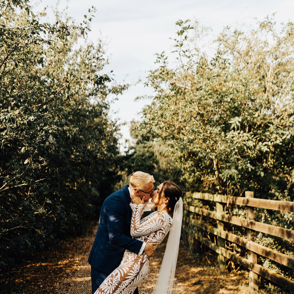 Bride & Groom kiss in forest setting at their unplugged ceremony at Elmley Nature Reserve
