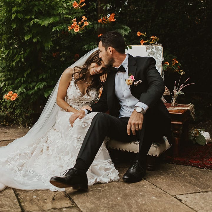 Bride leans into groom on their wedding day as he kisses her forehead