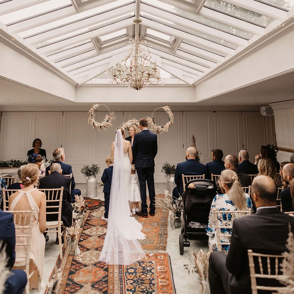 Bride & groom during wedding ceremony as guests watch on
