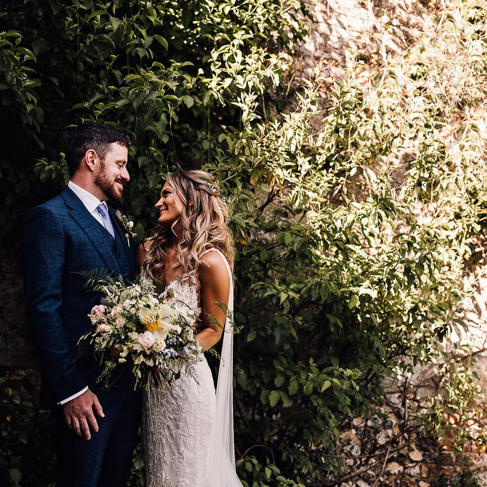 Bride and groom smile at each other for couple portraits 