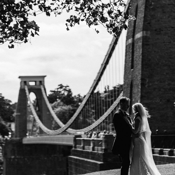 Bride and groom share an intimate embrace as they stand overlooking the Clifton suspension bridge in Bristol 