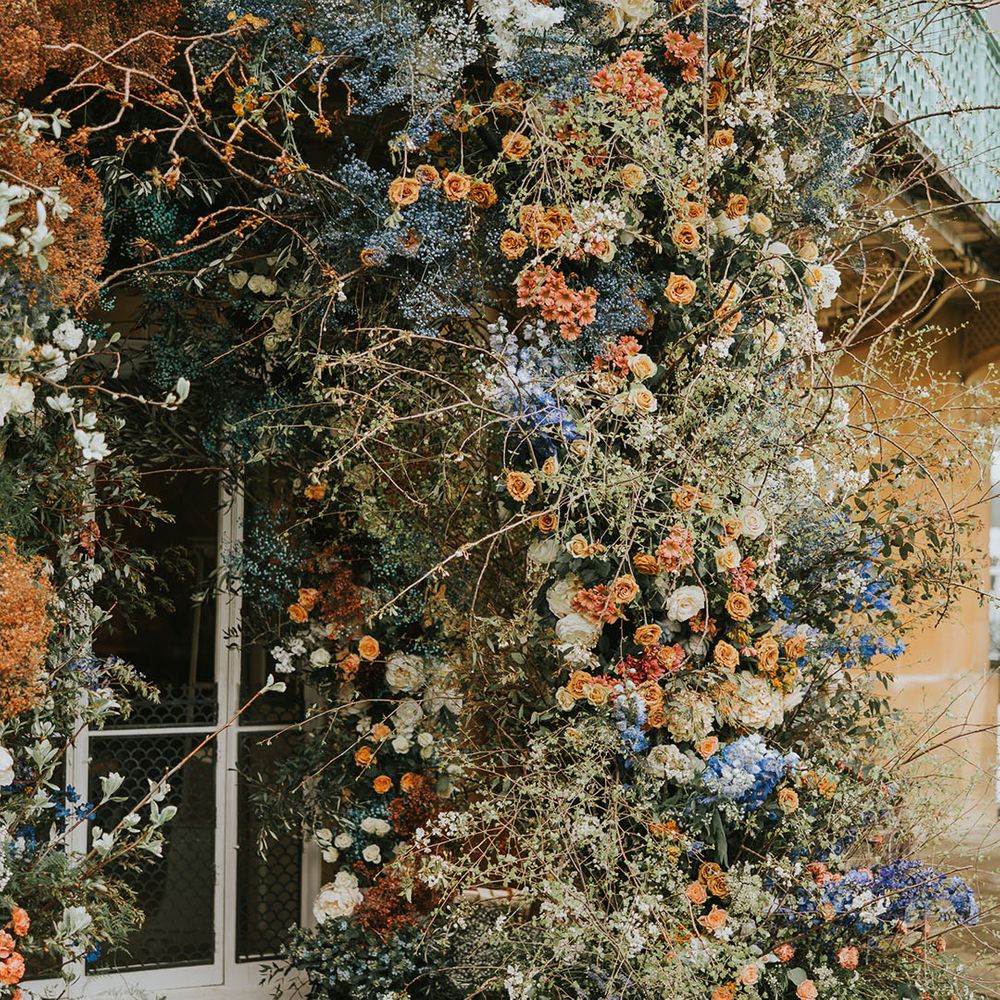 Blue, orange and white wedding flowers for a stunning wedding flower arch 
