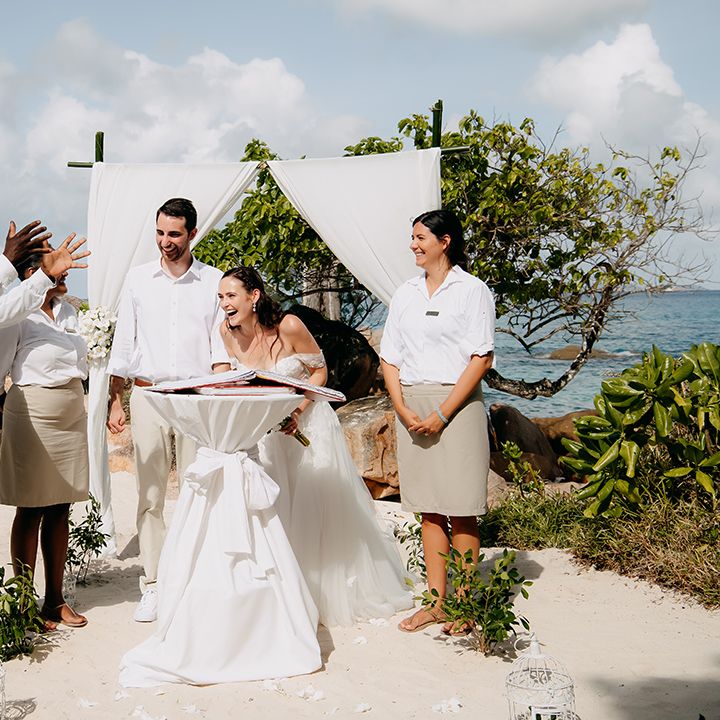 Bride and groom laughing at Seychelles elopement with witnesses from the hotel